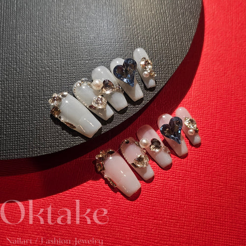 Elegant handmade press-on nails with pearl and sapphire charms, showcasing a professional and pristine appearance